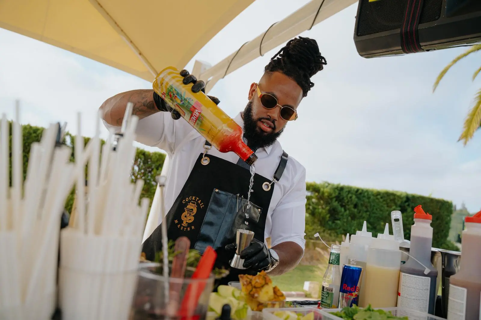 Cocktail Master bartender pouring a mixer at a garden party bar