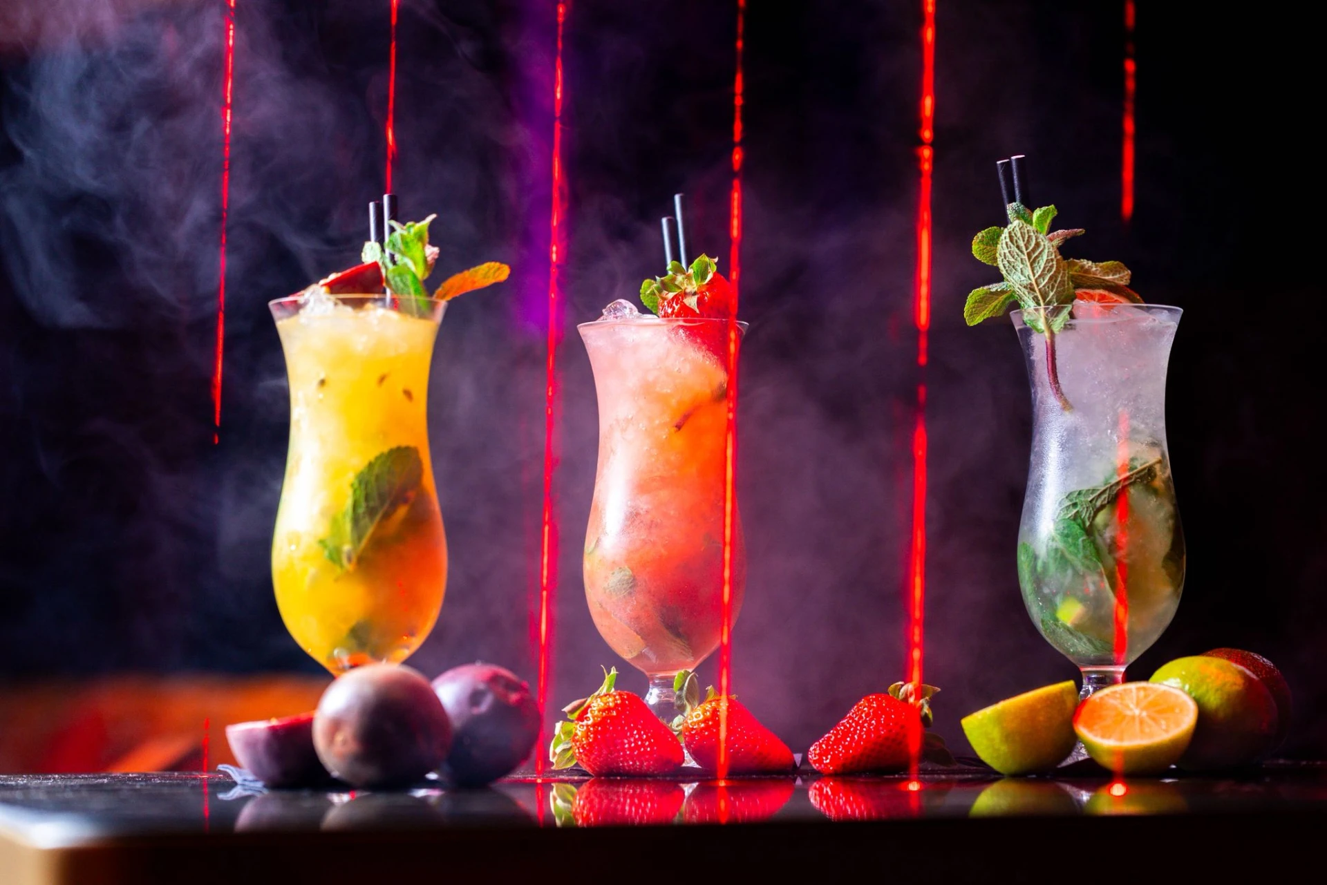 Cocktails lit with red light and smoke at an evening event