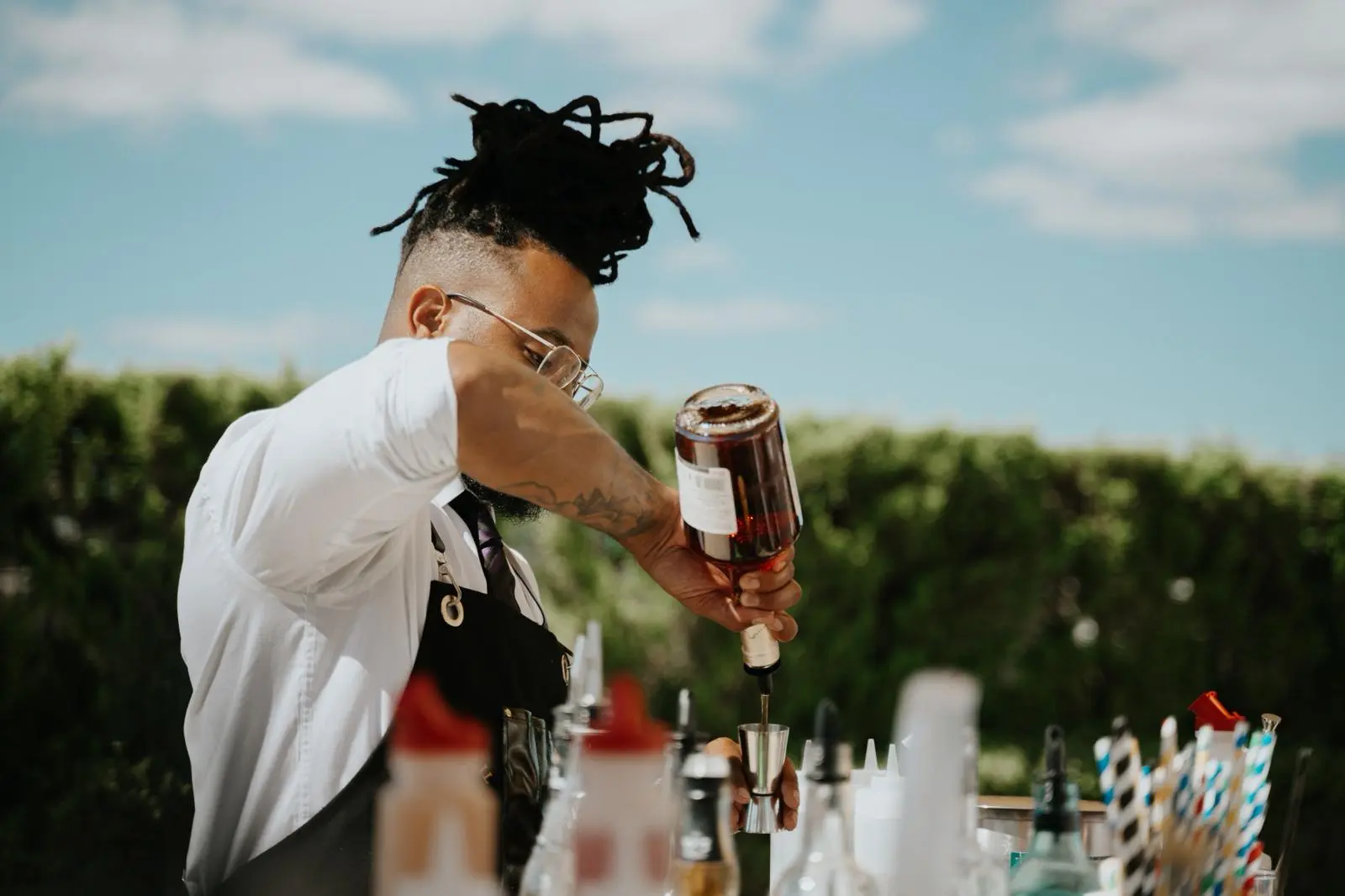 Bartender measuring spirits at an outdoor summer event