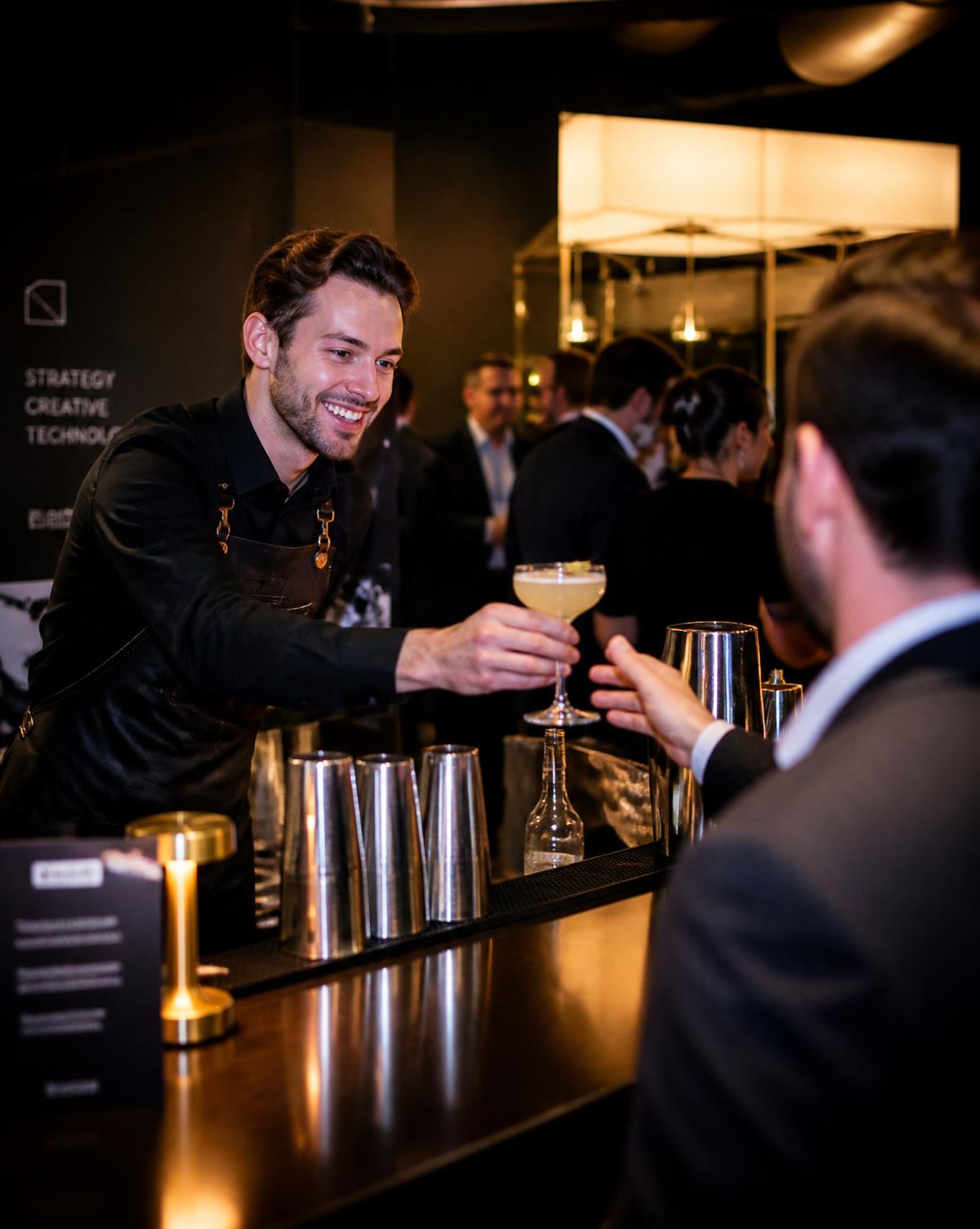 Bartender serving a cocktail to a guest at a corporate event